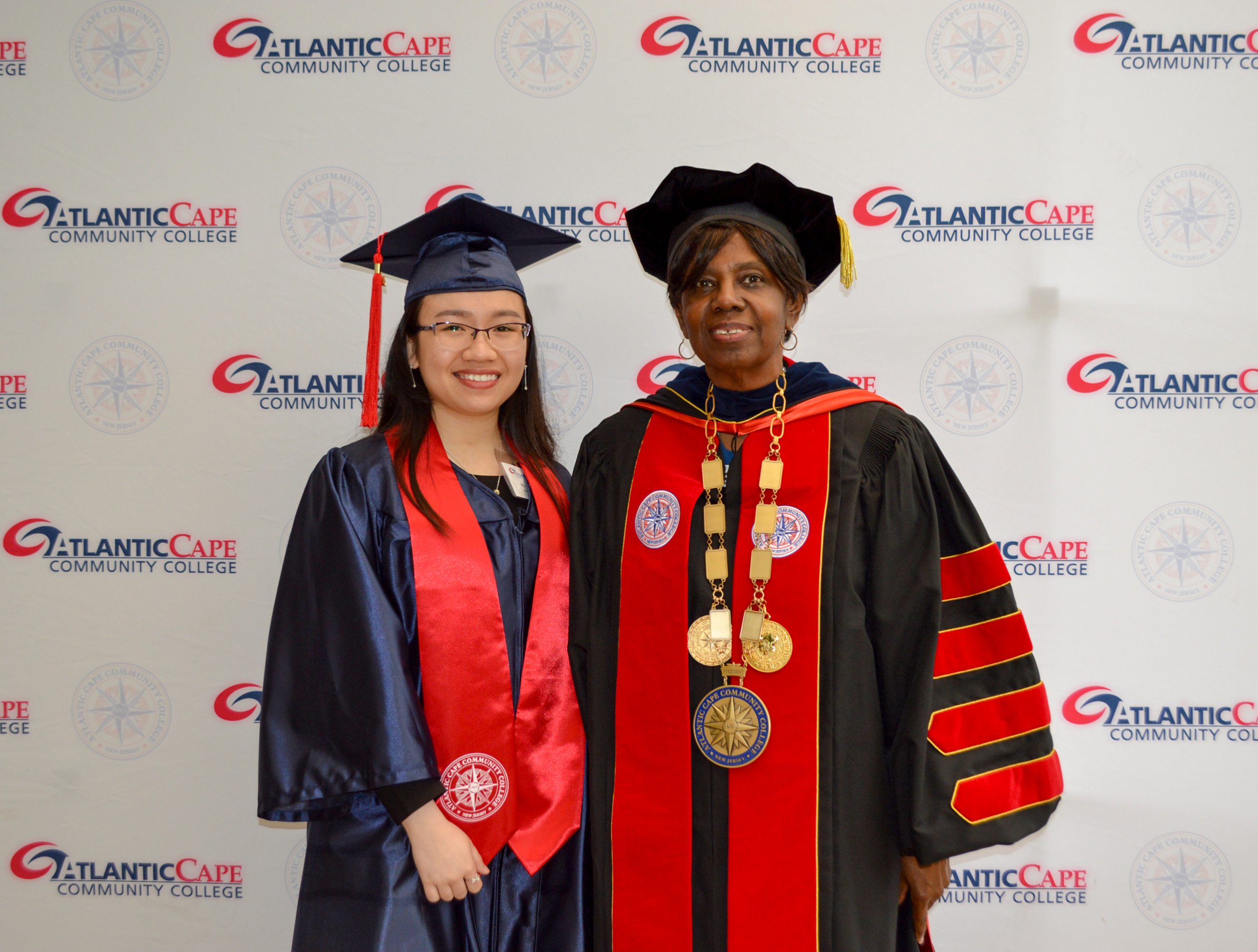 two women smiling in graduation regalia
